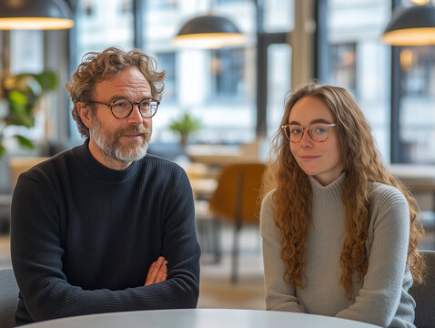 Un homme &acirc;g&eacute; accueille une jeune femme en entreprise : diversit&eacute;, junior et senior, relation interg&eacute;n&eacute;rationnelle, mentorat au travail, alternance ou stage