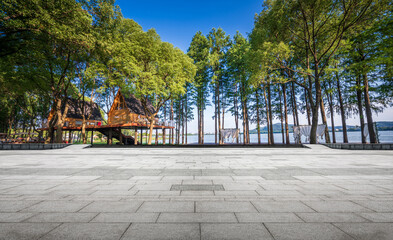 Serene Lakeside Pavilion Surrounded by Lush Greenery and Sunlit Waters