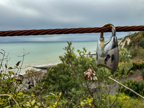 A padlock on the fence a the viewpoint at Holywell, in the resort town of Eastbourne, East Sussex, UK - Powered by Adobe