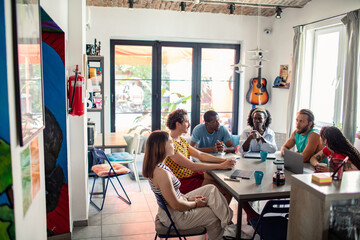 Diverse group of young adults having a serious discussion around a table indoors
