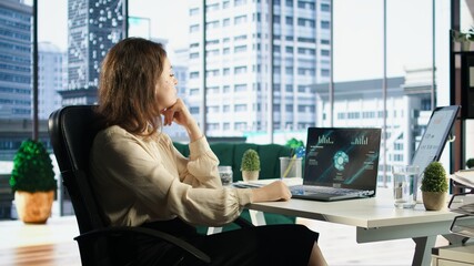 Young entrepreneur with leadership skills creates a financial report, demonstrating her expertise...