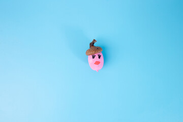 small pink acorn with red lips on blue
