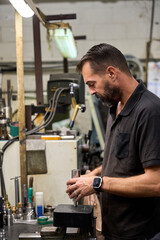 Metalworker assembling custom mechanical parts in metallurgy fabric