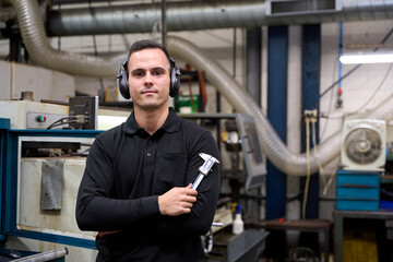 Metalworker holding caliper in custom mechanical parts factory: