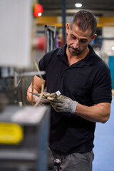 Metalworker finishing mechanical part in factory workshop
