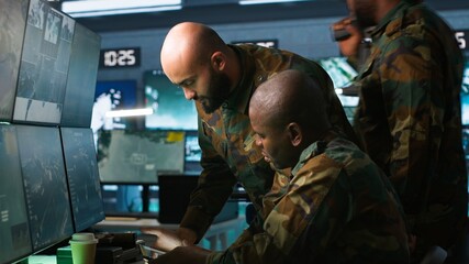 Military dispatcher helped by coworker with tablet to gain info from army intelligence analysts....
