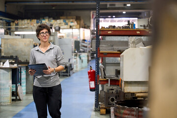 Female supervisor walking and inspecting a mechanical parts metallurgy fabric