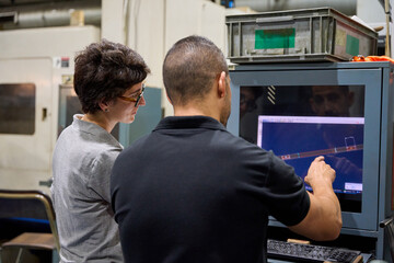 Engineers programming cnc machinery for custom mechanical parts metallurgy