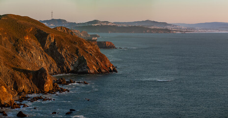 Pano showcases the rugged coastal cliffs of the Marin Headlands bathed in the warm light of the...