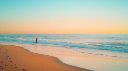 A lone figure walks along the sandy shore at sunrise, the gentle waves lapping at their feet