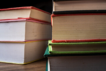 A close-up view of colorful stacked books on a wooden surface emphasizing education and learning...