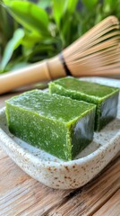 竹の茶筅と緑の背景を持つ伝統的な日本の抹茶羊羹