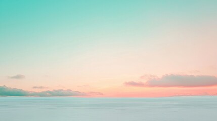Fototapeta premium Soft pastel colors paint the sky over a vast snow-covered landscape, creating a serene and dreamy winter scene during a beautiful sunset