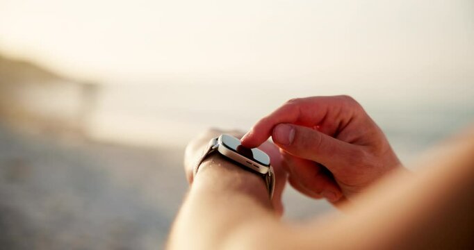 Person, hands and browsing with smart watch on beach for fitness tracker or step counter in nature. Closeup, runner or user with wristwatch app for checking calories, distance or performance by ocean