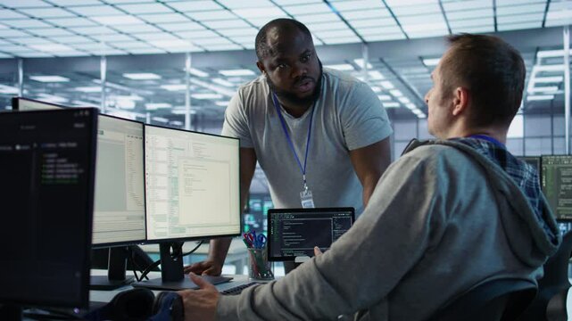 Engineer having fun with colleague at work in data center establishment, making jokes. Team of technicians making each other laugh, bonding in server room, doing fist bump gesture , camera B
