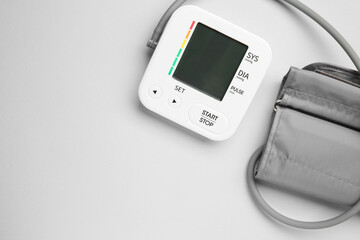 Blood pressure measuring device on light grey background, top view. Space for text