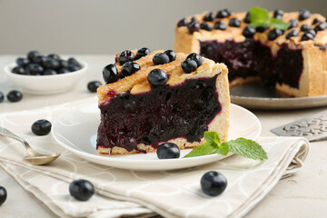 Slice of delicious homemade blueberry pie served on light table, closeup