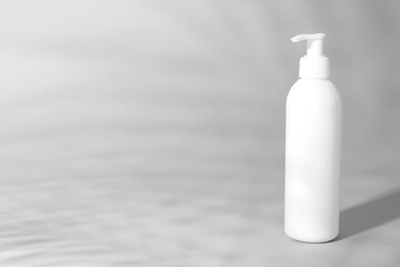 Shampoo in bottle on grey background, space for text
