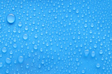 Water drops on blue background, top view