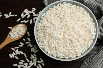 Puffed rice in bowl and spoon on wooden table, flat lay