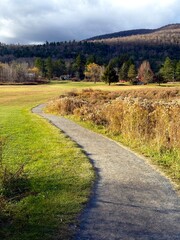 Obraz premium The winding Windham Path,in Windham, NY. Autumn fall foliage colors. Walk, bike or run among meadows, creeks, streams. Enjoy the mountain view and the small town countryside vibe. Charming ski town.