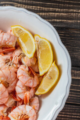 Boiled king prawns in a deep bowl with lemon
