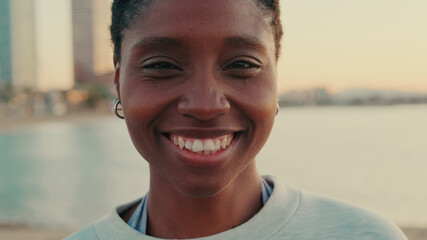 Calm young woman standing outdoor and smiling, enjoy moment of peace, mental relaxation and feels no stress concept