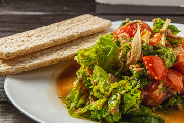 vegetable salad with tuna dressed with natural honey with rye bread closeup view