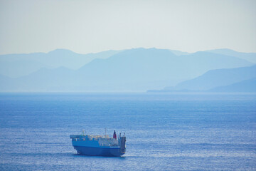 広大な海を背景に進む貨物船