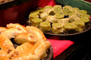 View of baklava, pistachio kadayıf wrap, kunefe, Turkish delight, nightingale's nest, cocoa baklava from the showcase of a dessert shop selling traditional Turkish desserts. Sherbet desserts. 