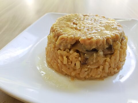 Loh mai kai made of Chinese glutinous rice. Chinese glutinous rice or known as loh mai kai served on white plate on a wooden table .Concept of processed asian food