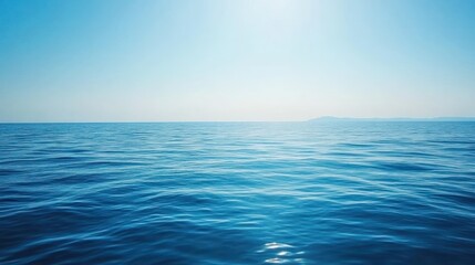 Obraz premium A vast, endless expanse of blue ocean water under a clear, sunny sky.