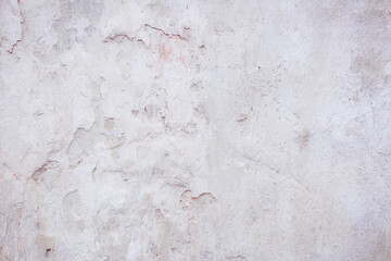 White concrete wall with natural defects. Fragment of the cement surface with natural texture. Monochrome palette of shades.