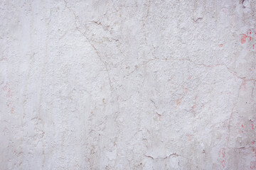 White concrete wall with natural defects. Fragment of the cement surface with natural texture. Monochrome palette of shades.
