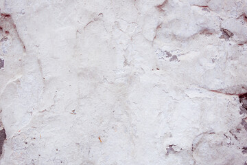 White concrete wall with natural defects. Fragment of the cement surface with natural texture. Monochrome palette of shades.