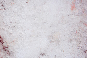 Grey peeling wall with natural defects. Fragment of the concrete shabby surface with natural texture. Red white palette of shades.