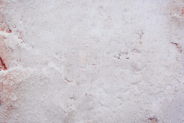 Grey peeling wall with natural defects. Fragment of the concrete shabby surface with natural texture. Red white palette of shades.