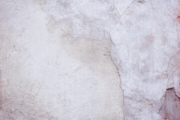 Grey peeling wall with natural defects. Fragment of the concrete shabby surface with natural texture. Red white palette of shades.