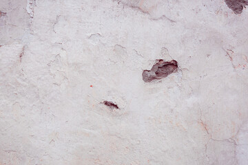 Grey peeling wall with natural defects. Fragment of the concrete shabby surface with natural texture. Red white palette of shades.