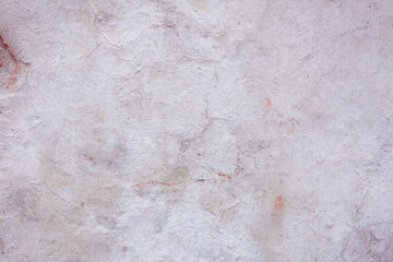 Grey peeling wall with natural defects. Fragment of the concrete shabby surface with natural texture. Red white palette of shades.