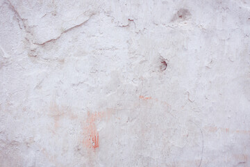 Grey peeling wall with natural defects. Fragment of the concrete shabby surface with natural texture. Red white palette of shades.