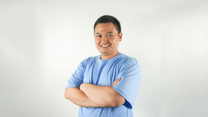 A young Indonesian man wearing a blue t-shirt with a smiling face facing forward