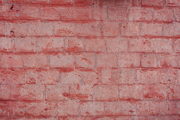 A fragment of a red brick wall with pronounced texture. Natural age defects in the form of cracks...