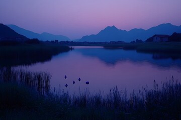 Fototapeta premium A serene twilight landscape with mountains reflecting in a calm lake.