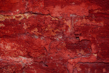 A fragment of a red brick wall with pronounced texture. Natural age defects in the form of cracks...
