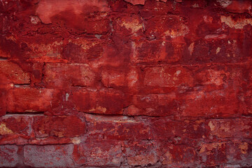 A fragment of a red brick wall with pronounced texture. Natural age defects in the form of cracks and abrasions. Rough surface with traces of dried paint.
