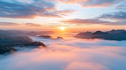 Obraz premium Breathtaking sunrise illuminates misty mountain landscape with ethereal glow and tranquil atmosphere