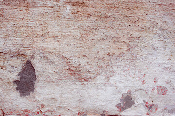 Grey concrete wall with natural defects. Fragment of the cement surface with natural texture. Natural cracked plaster on a light wall. Textured background for integration into the design.