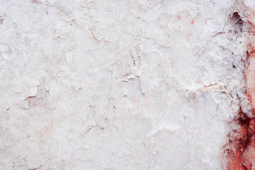 Grey concrete wall with natural defects. Fragment of the cement surface with natural texture. Natural cracked plaster on a light wall. Textured background for integration into the design.