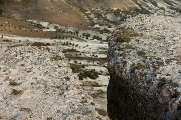 Man standing on top of rock with backpack and skateboard in hand, adventure travel concept